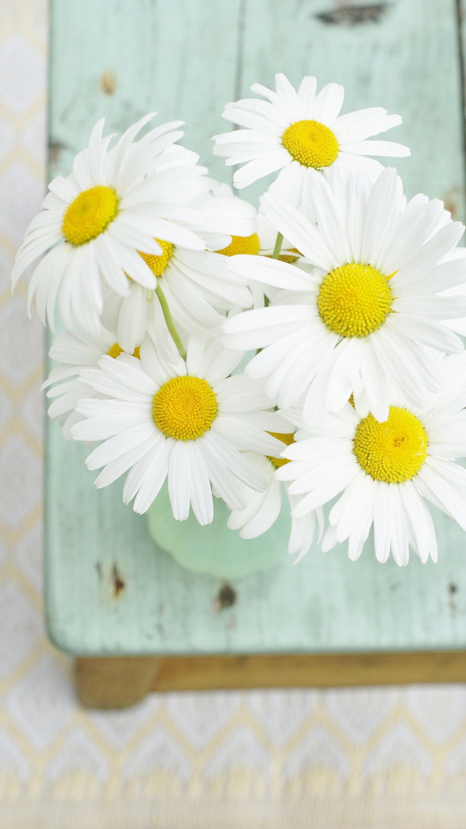 Un vase avec un bouquet de marguerites sur une table (marguerites, fleurs)