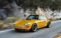 Porsche 911 clássico em amarelo vibrante, capturado em um passeio cênico.