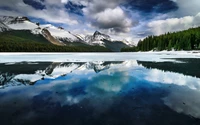 Beeindruckende Reflexion der Gletscherberge und bewölkten Himmel am Maligne Lake, Kanada