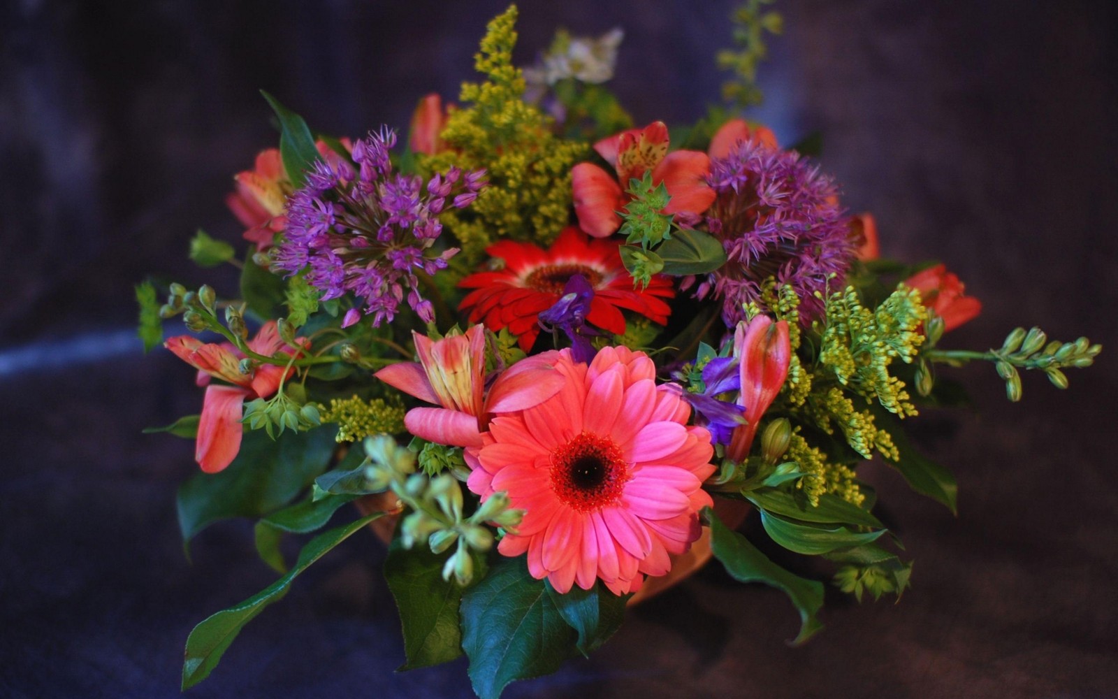 Il y a un vase de fleurs qui est posé sur une table (marguerite du transvaal, bouquet de fleurs, lys des incas, arrangement floral, fleuristerie)