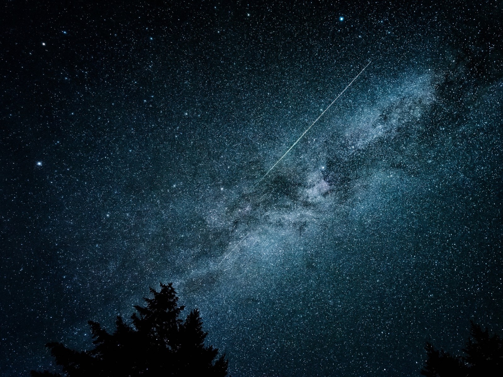 Um close de um avião voando pelo céu noturno (noite, galáxia, objeto astronômico, estrela, natureza)