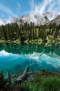 Lago glacial tranquilo que refleja montañas majestuosas y una exuberante naturaleza