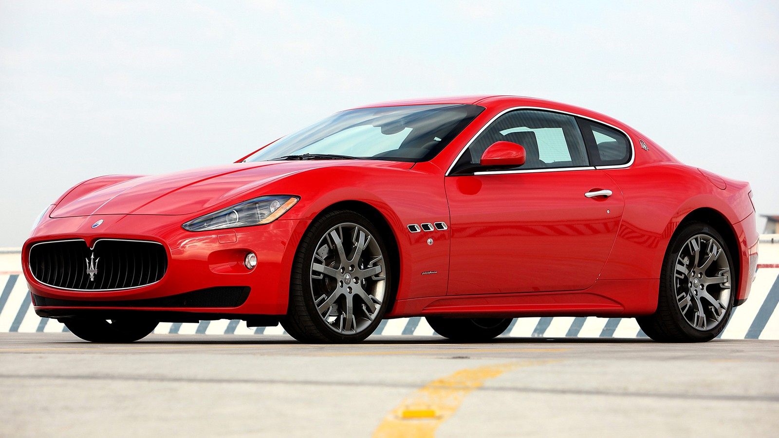 A close up of a red maserat parked on a runway (maserati, sports car, car, grand tourer, maserati granturismo)