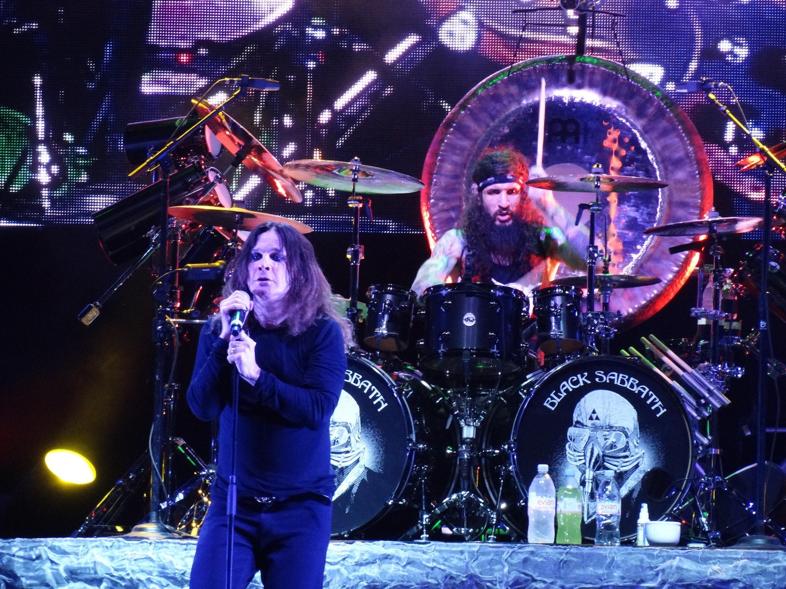 Una imagen de una mujer cantando en el escenario con un micrófono (baterista, ozzy osbourne, concierto de rock, black sabbath, tambor)