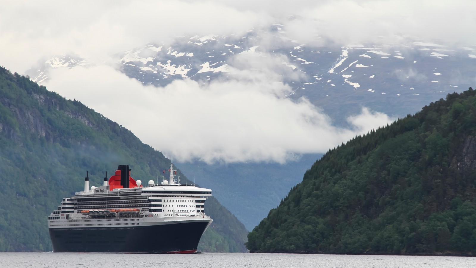 Ein kreuzfahrtschiff im wasser mit bergen im hintergrund (schiff, kreuzfahrtschiff, passagierschiff, fjord, wassertransport)