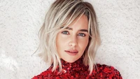 Emilia Clarke en un deslumbrante atuendo rojo con una mirada cautivadora.