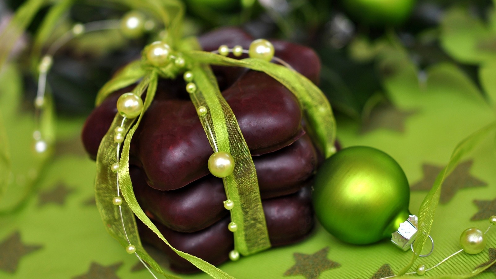 There is a green and red ornament and a green ornament (new year, christmas day, holiday, fruit, produce)