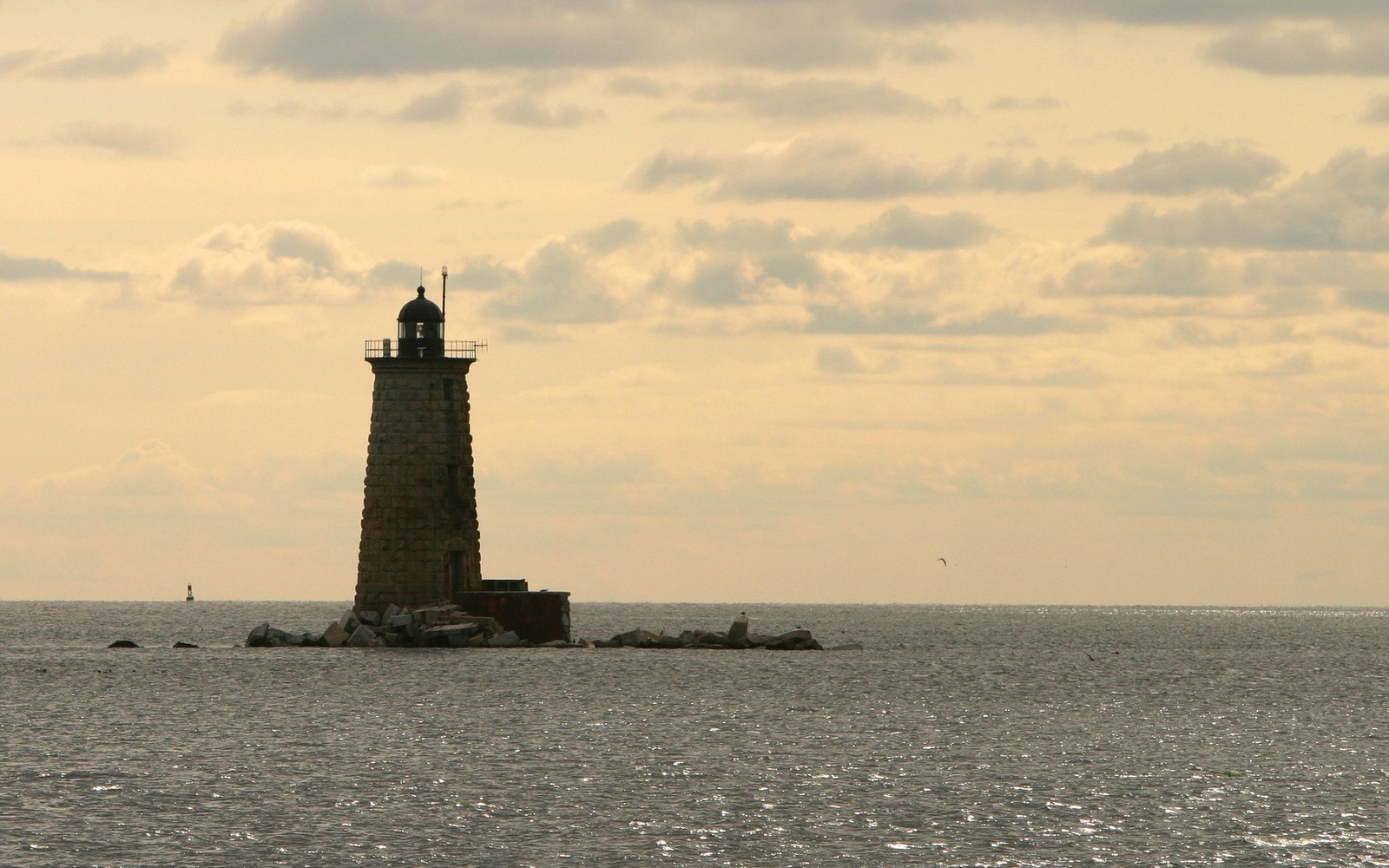 Há um farol no meio do oceano com um barco na água (mar, torre, farol, horizonte, oceano)