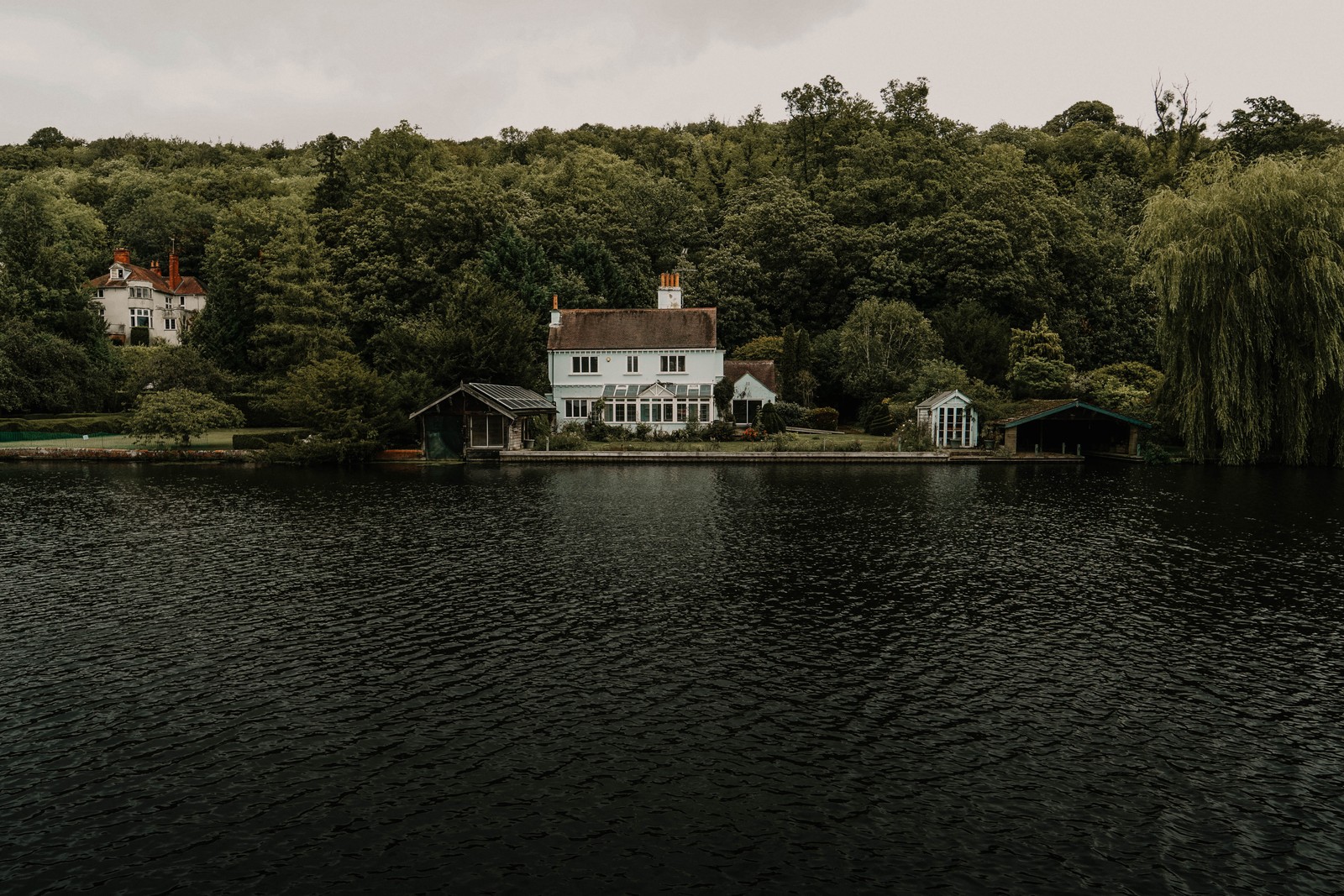 Vue d'une maison au bord d'un lac avec un bateau dans l'eau (ciel, lac, bâtiment, nature, réservoir)