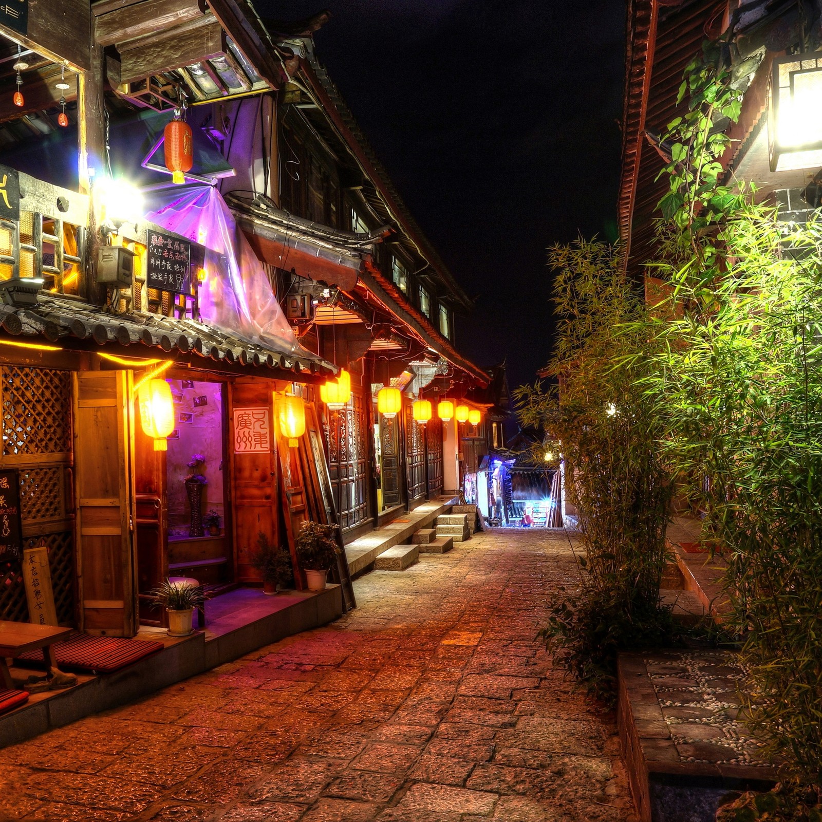 Vista nocturna de una calle con un restaurante iluminado. (asia, asiático, china, chino, ligero)