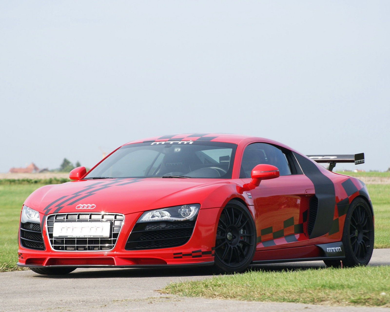 Un primer plano de un coche deportivo rojo en la carretera cerca de un campo (audi, coche, alemania)