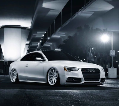 Elegante Audi S5 branco à noite sob luzes urbanas