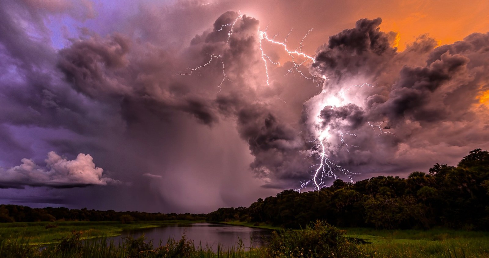 Un gros plan d'un éclair frappant un nuage au-dessus d'un lac (orage, tempête, nuage, nature, tonnerre)