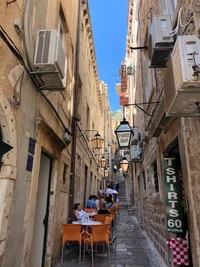 Charmante Gasse in einer historischen Stadt mit Außenbewirtung und lokalen Geschäften