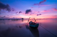 Bateau à rames serein au coucher du soleil : un reflet des eaux tranquilles sous un ciel violet