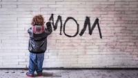 Arte de grafite infantil: "MAMÃE" em uma parede de tijolos