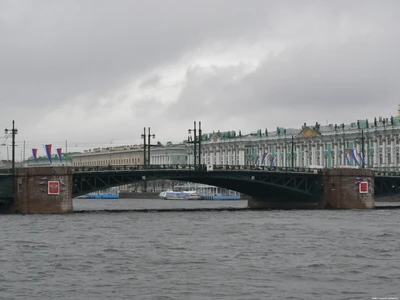 Городской мост через реку с моторной лодкой и историческими зданиями