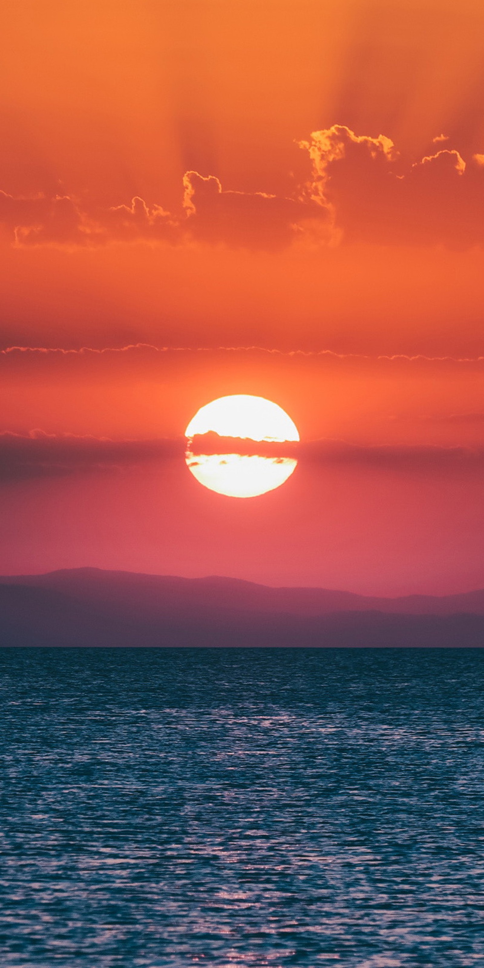 Vue arabe d'un coucher de soleil sur l'océan avec un bateau sur l'eau (horizon, soundcloud, eau, nuage, atmosphère)