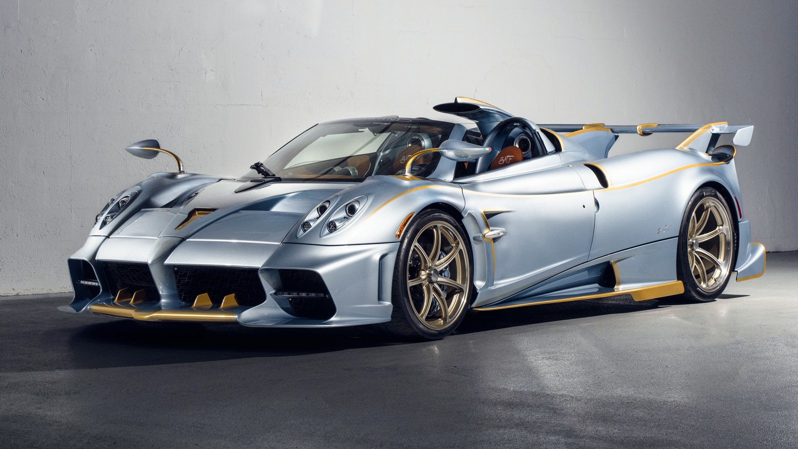 A silver and gold sports car parked in a garage (pagani imola roadster, 5k, supercar, cars, 4k wallpaper)