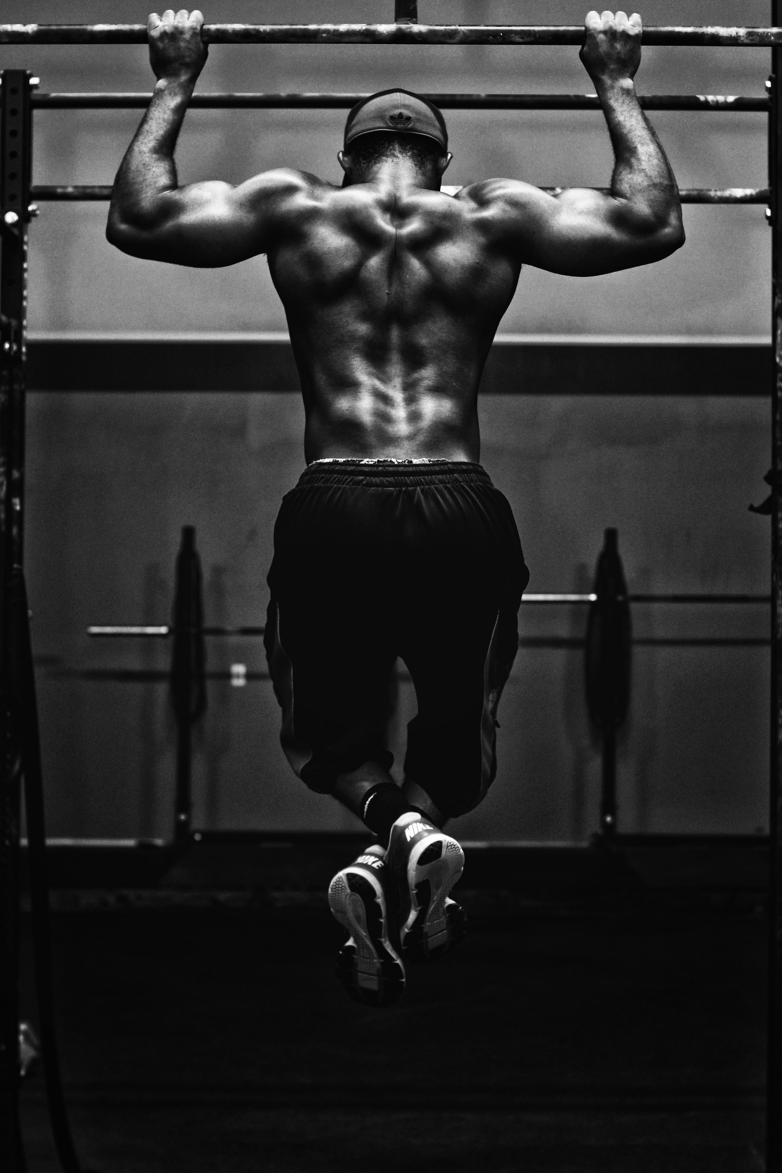 Homem árabe fazendo pull-ups em uma academia com uma barra (centro de fitness, masculino, exercício, em pé, braço)