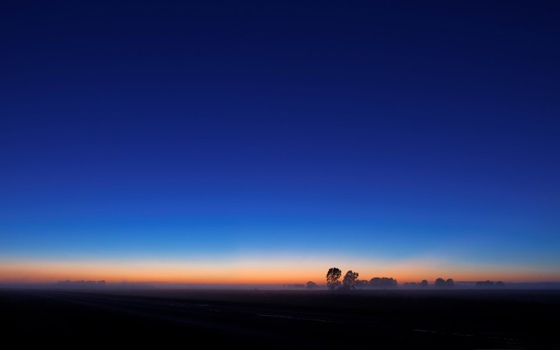 Une vue d'un coucher de soleil avec un nuage et un avion au loin (ciel nocturne, horizon, crépuscule, atmosphère, journée)