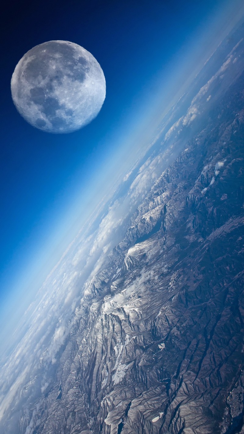 Vista desfocada da lua sobre uma cadeia de montanhas a partir da janela de um avião (azul, terra, planeta)