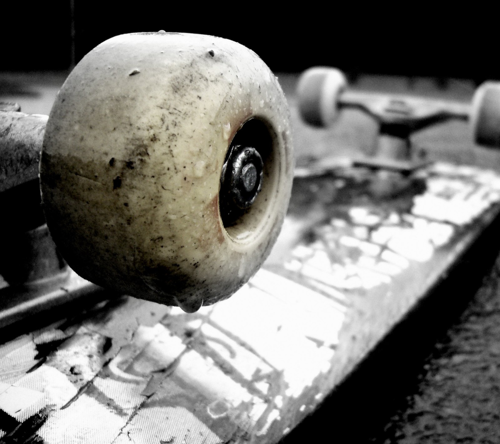 There is a skateboard that is sitting on a concrete surface (decks, skateboard)