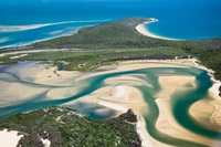 Vista aérea de um estuário cênico com entrada e promontório curvando-se para o oceano