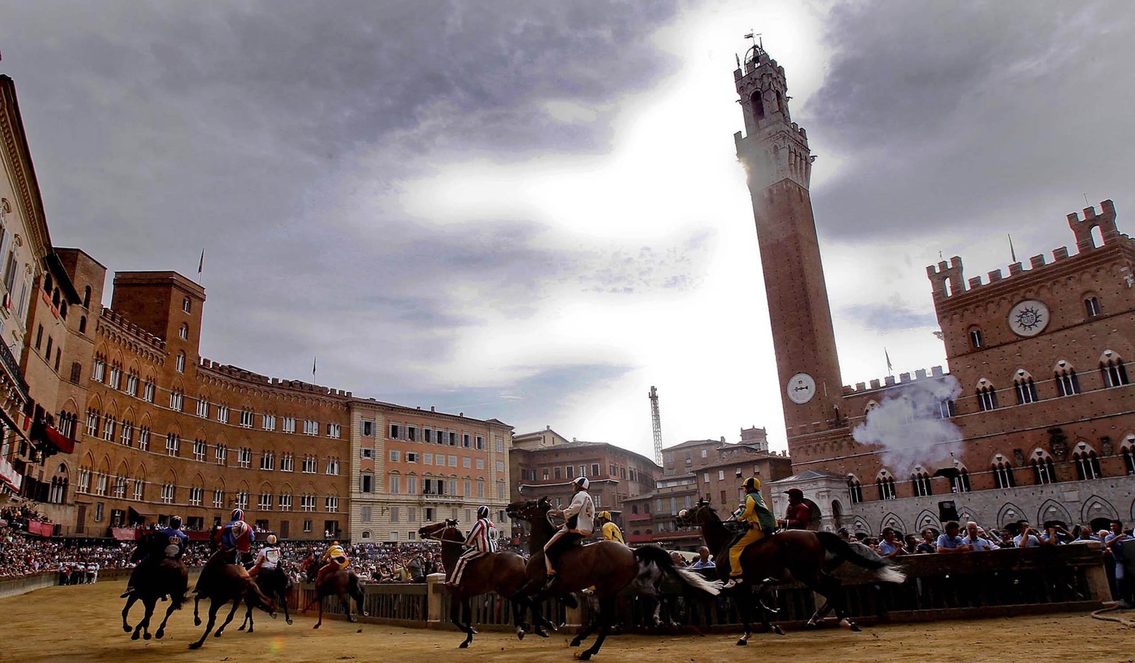 Cavalos e cavaleiros em um círculo com uma torre do relógio ao fundo (cavalo, praça da cidade, cidade, marco, praça)