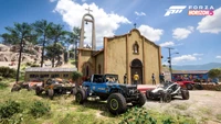 Veículos off-road estacionados em frente a uma charmosa igreja em Forza Horizon 5