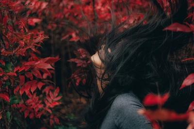 Serenity Amidst Red Leaves: An Asian Woman Embracing Nature