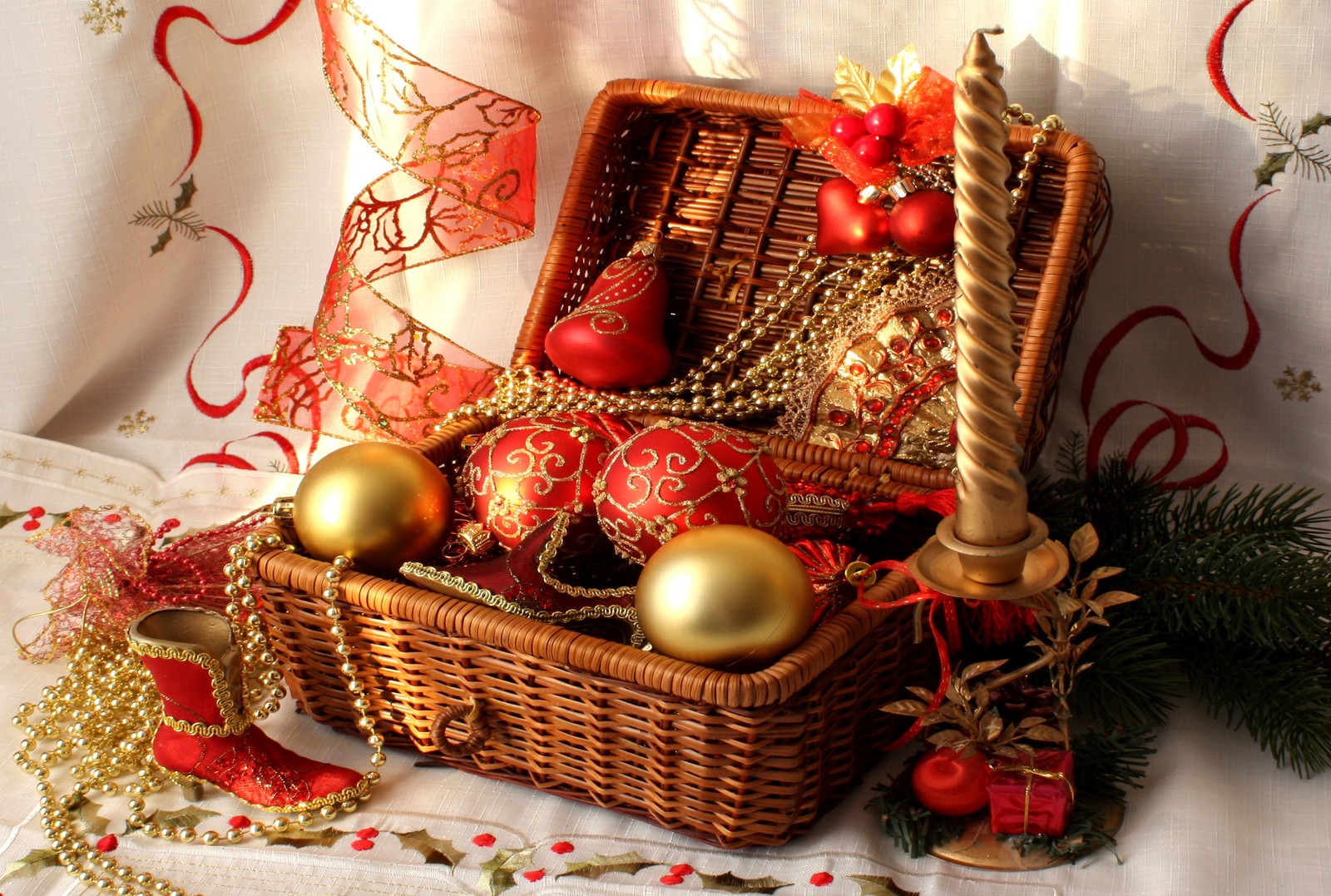 There is a basket with ornaments and decorations on a table (christmas decoration, christmas day, christmas ornament, christmas tree, holiday)