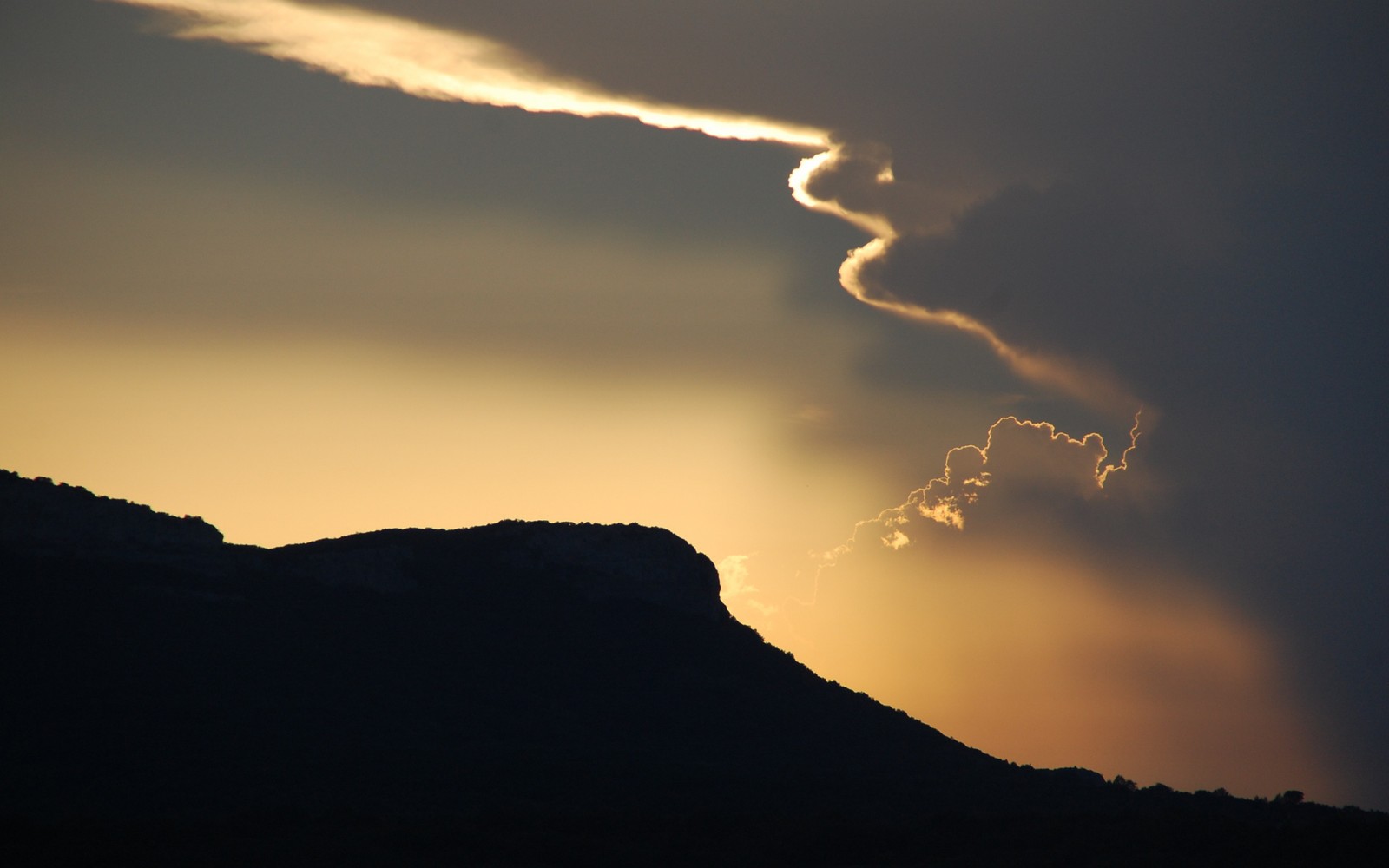 Un nuage dans le ciel avec une ligne de fumée qui s'en échappe (nuage, soir, ensoleillement, horizon, nuages)