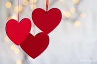 Rote Herzen, die vor einem sanften Bokeh-Hintergrund für den Valentinstag hängen