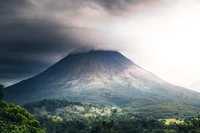 Vulcão Arenal envolto em nuvens: uma paisagem majestosa de aventura e natureza.