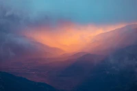 Crepúsculo sobre as montanhas altas: Um brilho atmosférico entre nuvens cúmulo