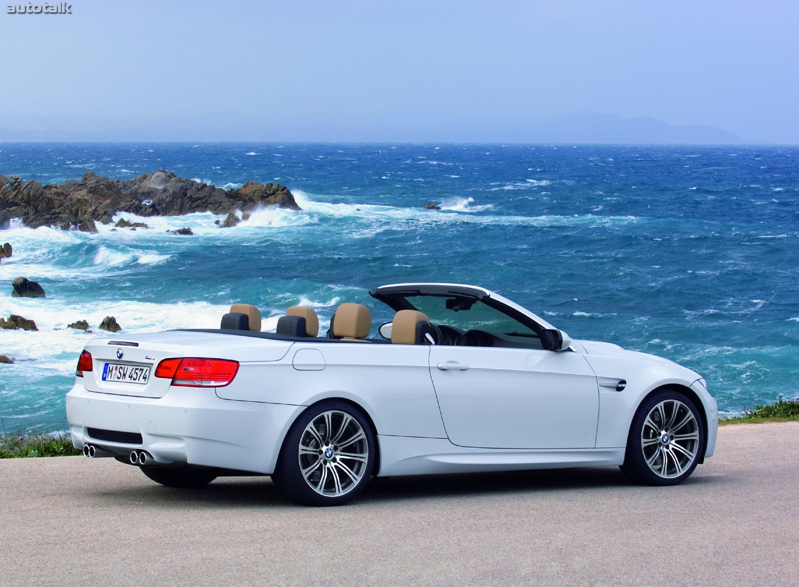 Arafed white bmw convertible parked on a road near the ocean (car, sports car, convertible, bmw, sportscar)