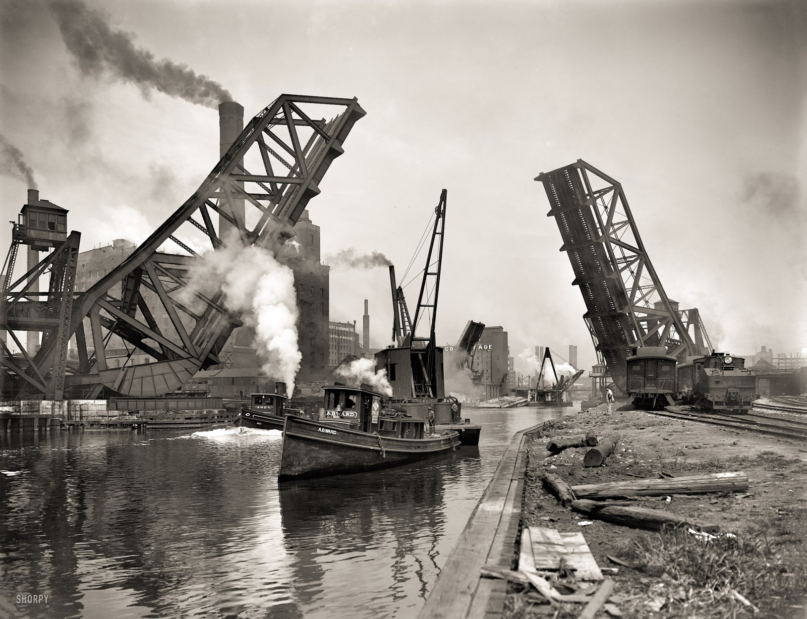 Há um barco passando por baixo de uma ponte na água. (chicago, indústria, metal, barco, guindaste)