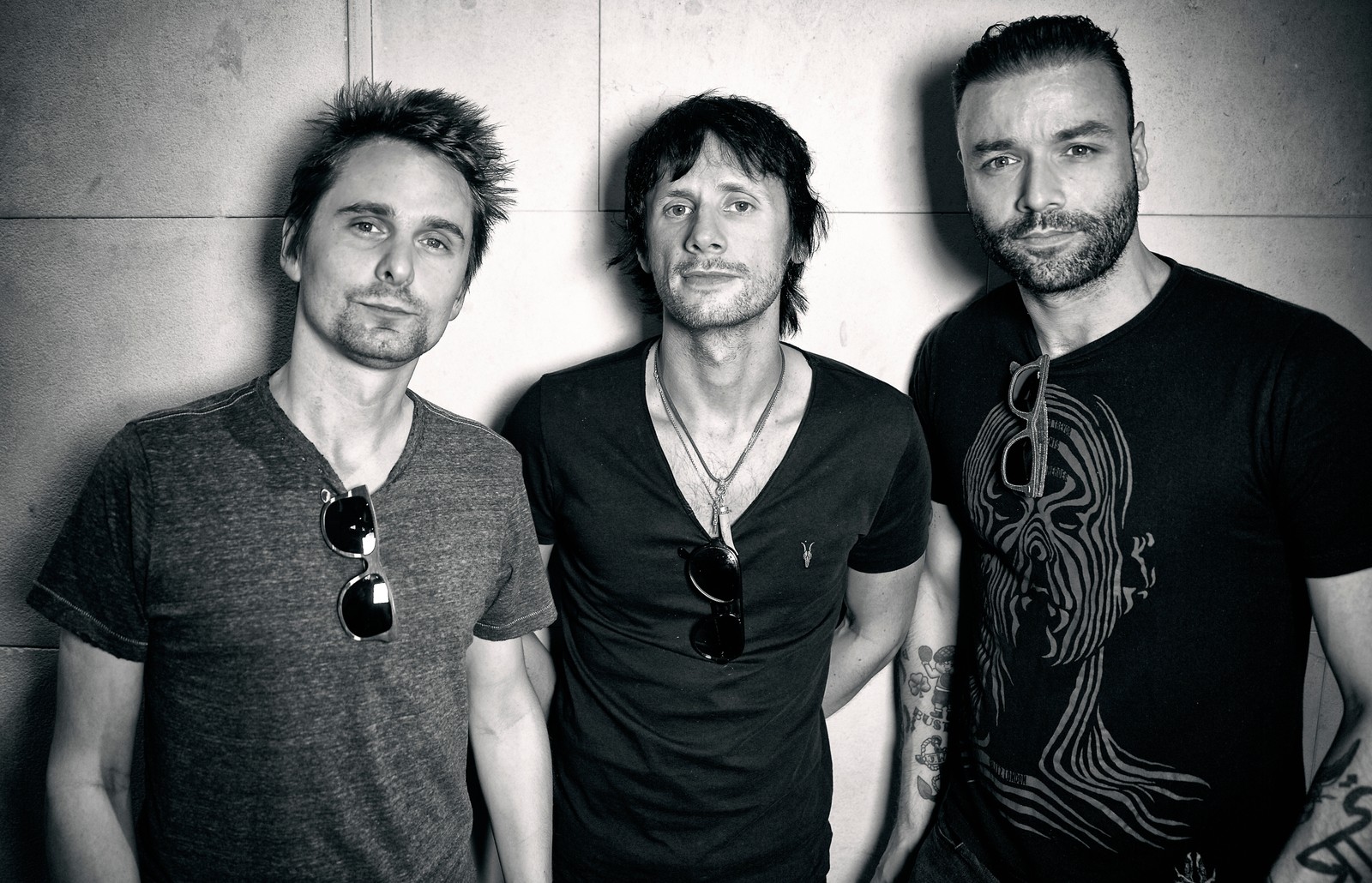 Three men standing next to each other in a black and white photo (musical ensemble, musician, facial hair, fun, cool)