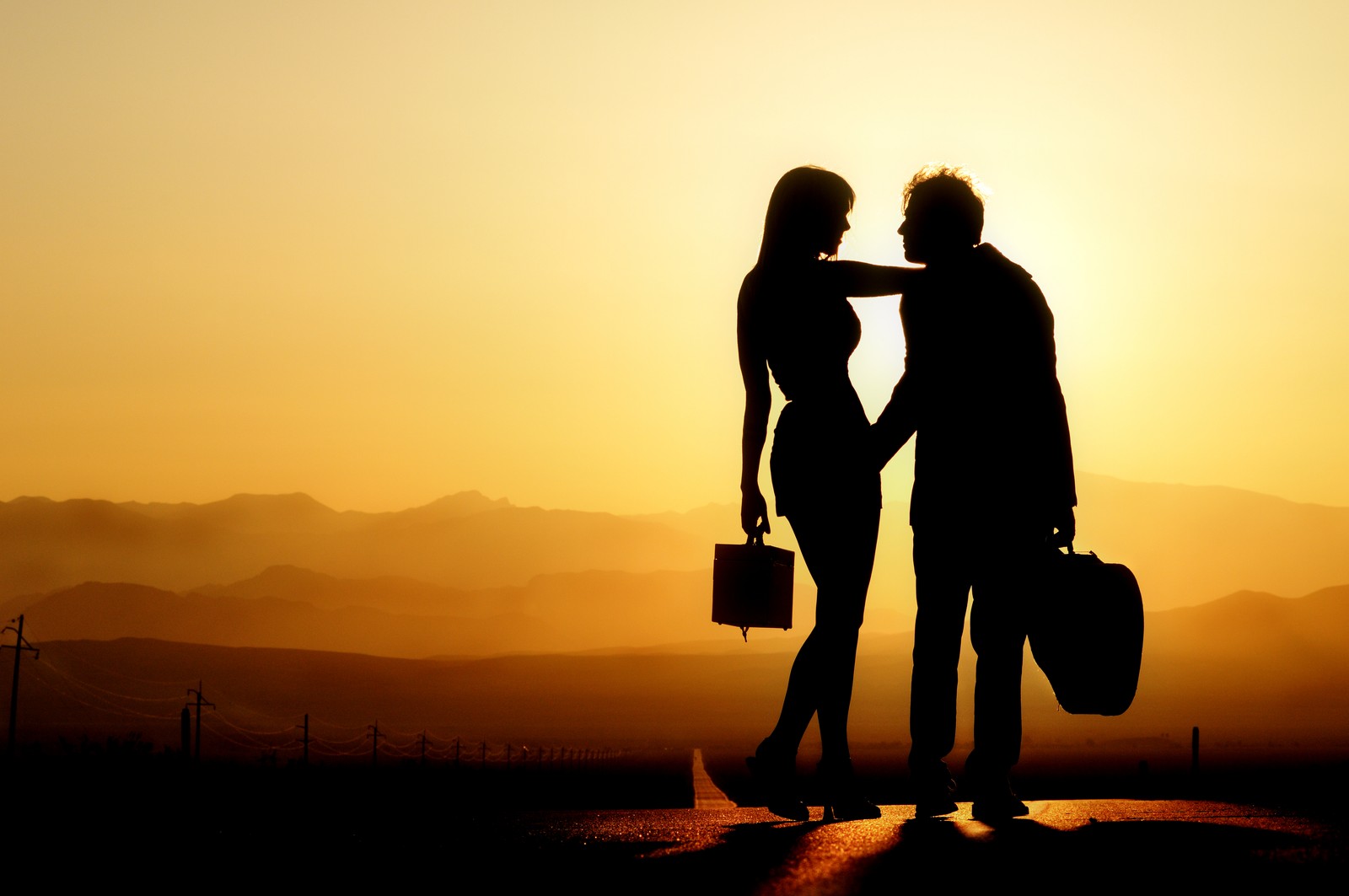 Silhouette d'un couple se tenant par la main et marchant sur une route (silhouette, coucher de soleil, amour, matin, ensoleillement)