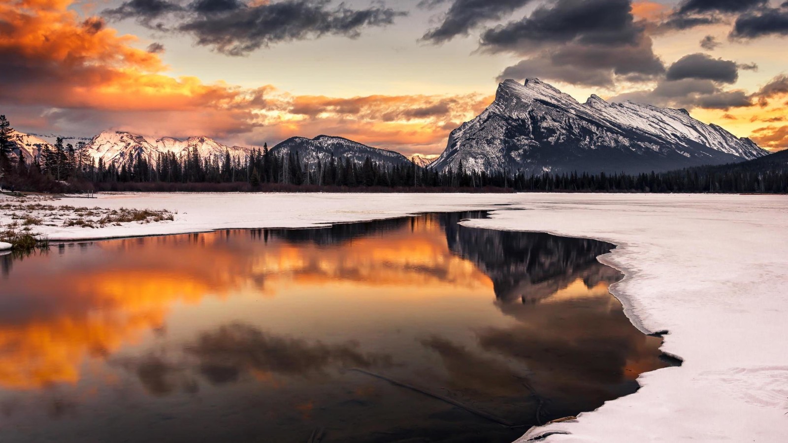 A view of a lake with snow and mountains in the background (mount rundle, banff, mountain, natural landscape, nature)