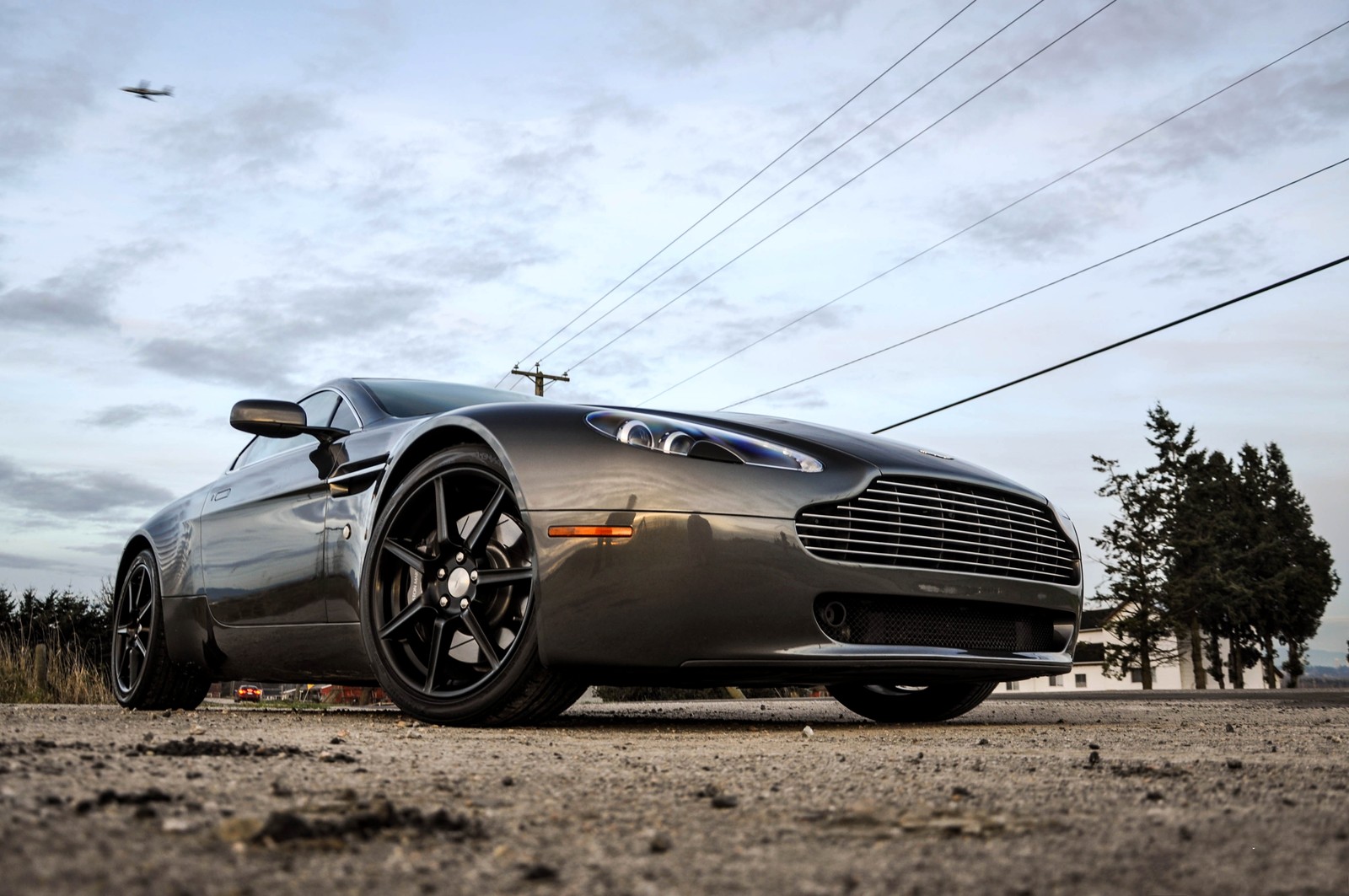 Vue d'une voiture garée sur une route avec des lignes électriques en arrière-plan (voiture de sport, aston martin virage, aston martin dbs v12, aston martin db9, aston martin vanquish)