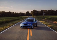 Carro esportivo BMW Z3 em uma estrada aberta ao pôr do sol