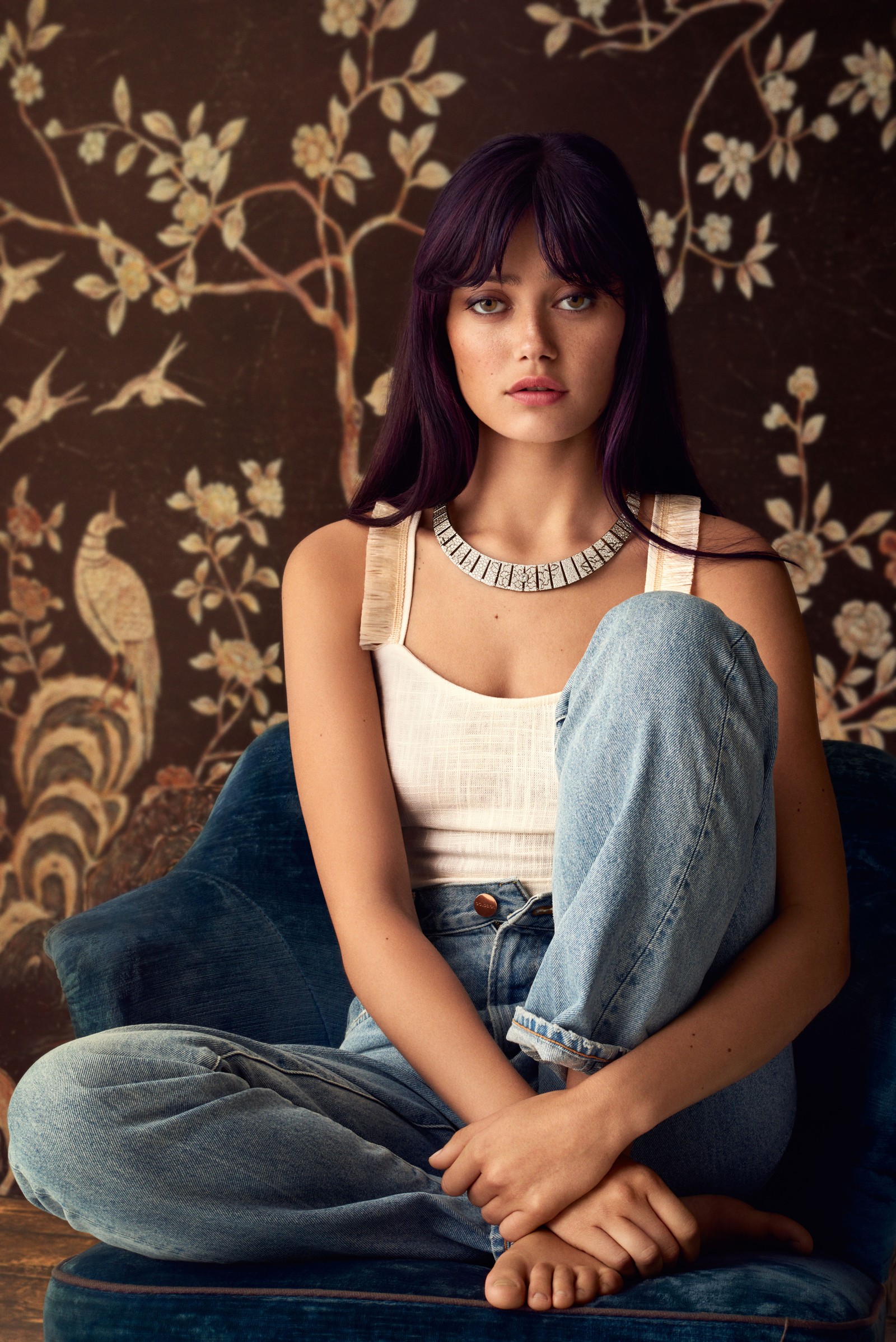 Arafed woman sitting on a blue chair with a necklace on her neck (ella purnell, english actress, vanity fair, 5k, people)