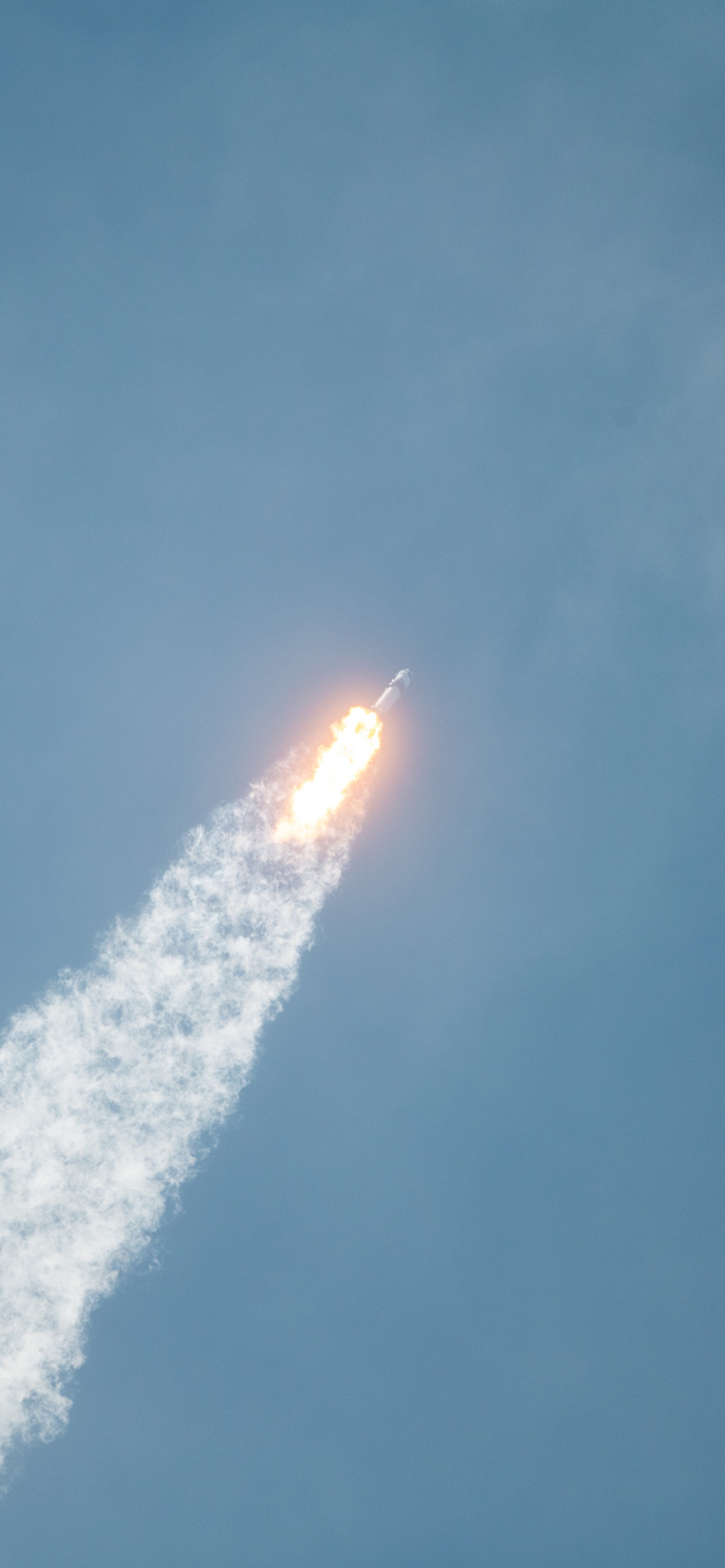 There is a jet flying through the air with a trail of smoke (spacex, human spaceflight, international space station, atmosphere, amber)