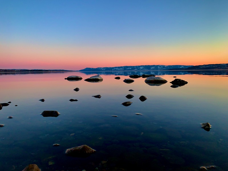 Вид на озеро с камнями и водой на закате (mjøsa lake, норвегия, закат, сумерки, красное небо)