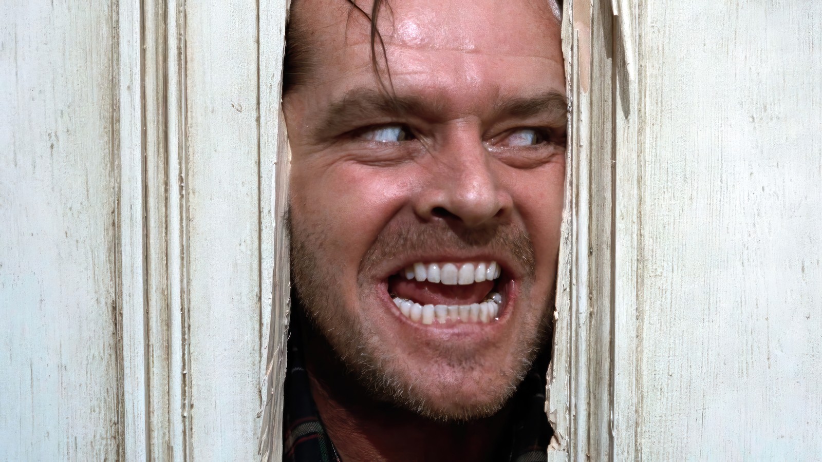 Размытый мужчина с бородой и улыбкой выглядывает из двери (heres johnny, the shining, фильм)