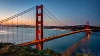 Puente Golden Gate al anochecer: un majestuoso hito enmarcado por el cielo crepuscular y aguas tranquilas.