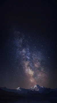 Majestuoso cielo nocturno con la Vía Láctea sobre montañas cubiertas de nieve