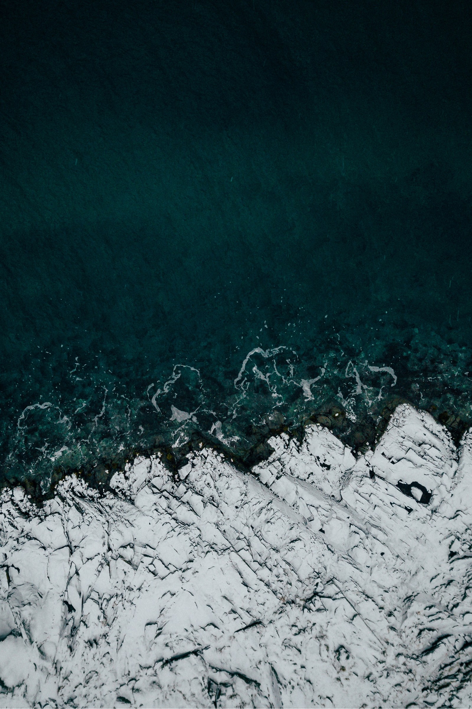 Aerial view of a body of water with a boat in it (and, nature, sea, snow, water)